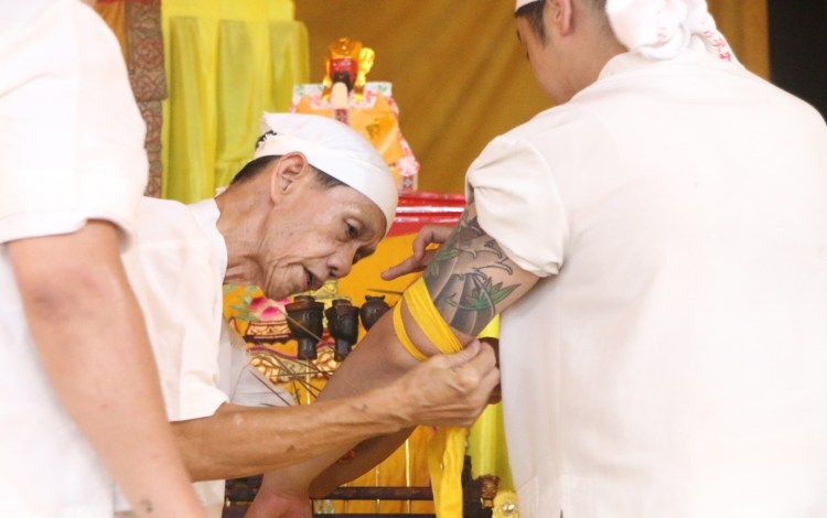 Uncle Ah Huat assisting James in the wearing of the Heavenly Generals.