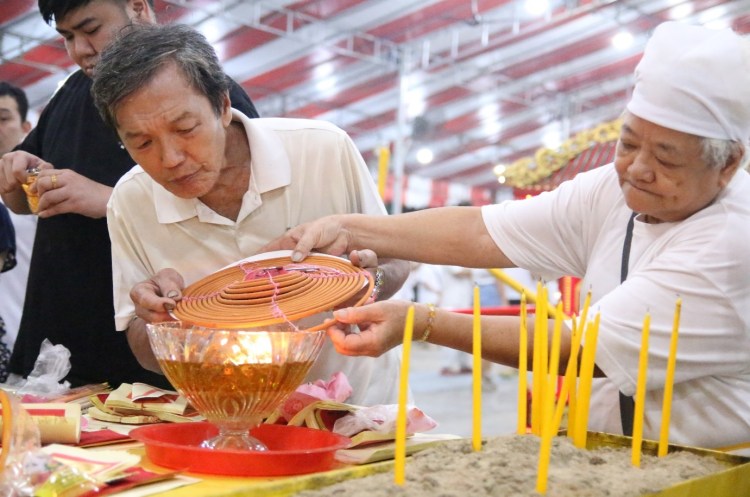 After the Nine Lamps are raised, devotees pay their respect to the Nine Emperor Gods by offering Joss sticks and burning of incense paper.