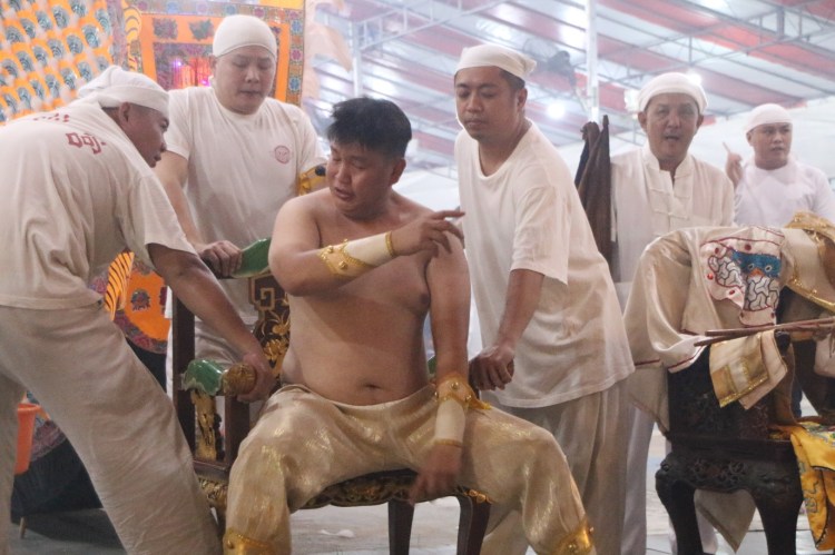 The trancing of Zhong Tan Yuan Shuai before heading to Changi Beach. He also provides instructions along the way to the temple assistants during the receiving process.